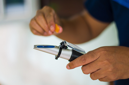 Fruit juice being applied to a manual refractometer. 